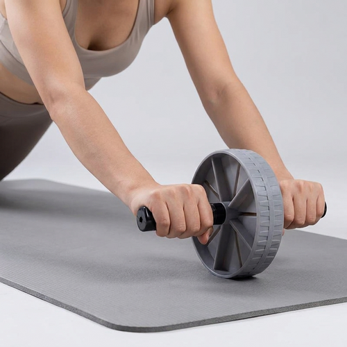 Woman using the Ab Roller Wheel on a yoga mat